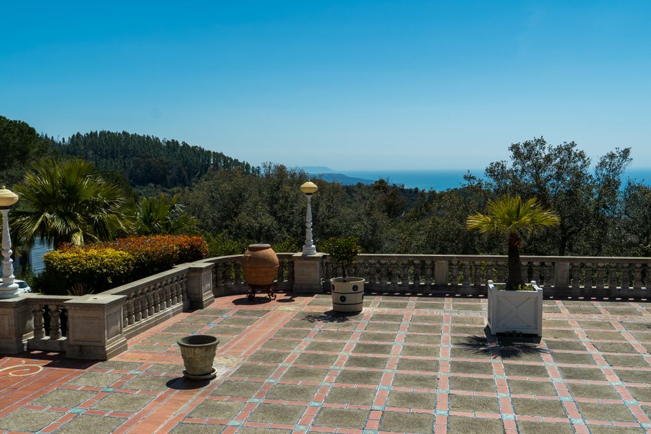 Elegant terrace with ocean view surrounded by lush gardens, perfect for relaxation or events.